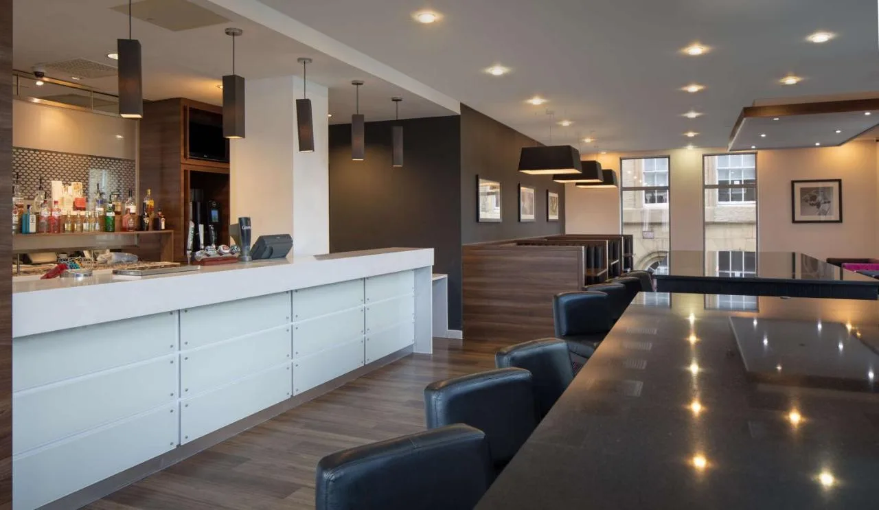 a bar with a long table and some chairs at Hampton by Hilton York in York