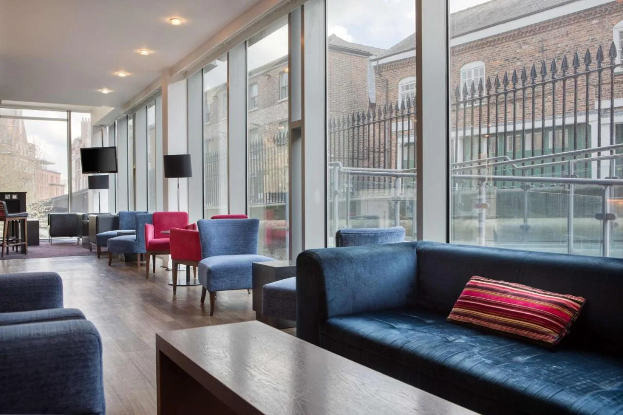 a lobby with a couch and chairs and windows at Hampton by Hilton York in York