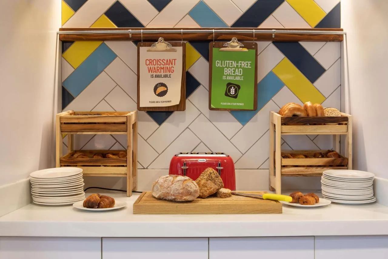 a bakery counter with bread and pastries and plates at Hampton by Hilton York in York